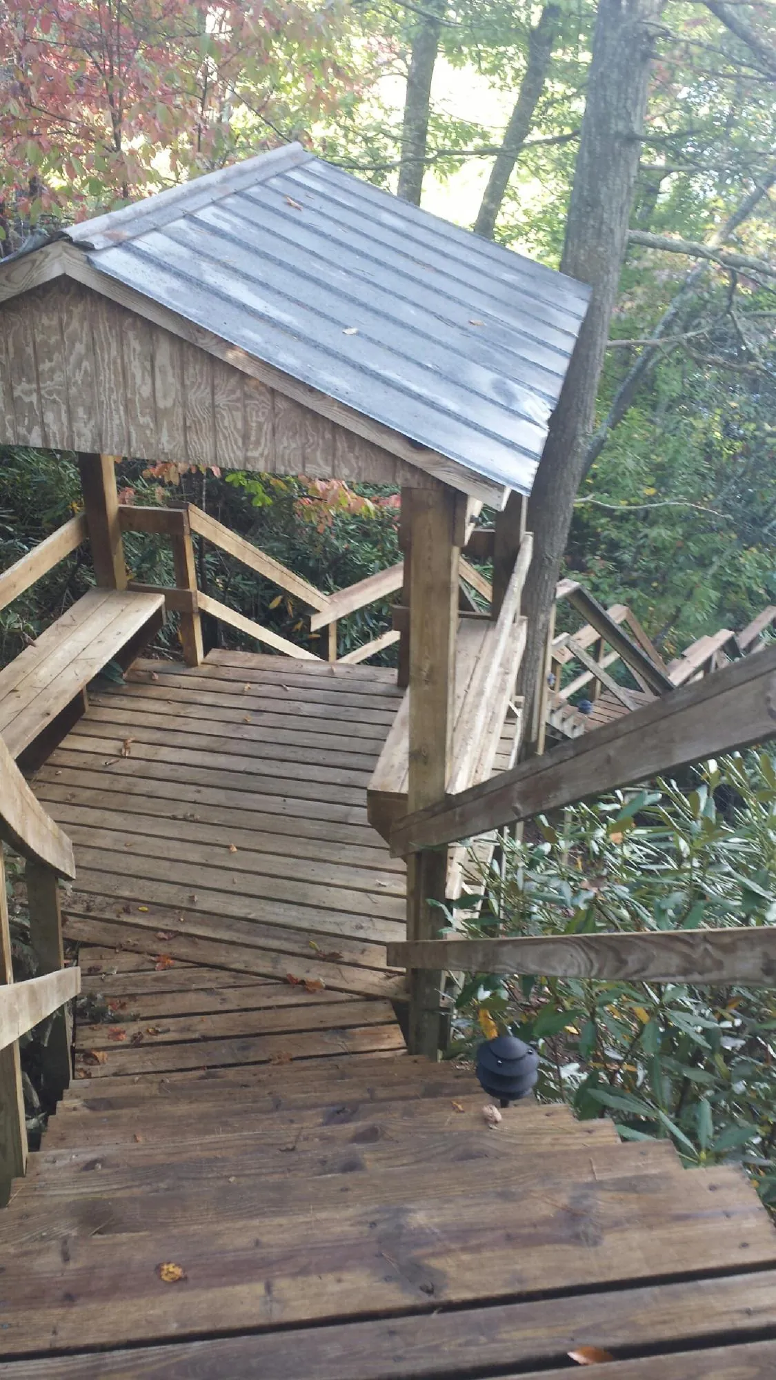 Metal roofed shelter over wooden steps on a wooded walkway — Skylight Repair & Installation work by our crew in Glendo